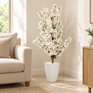 Arbre artificiel à fleurs blanches avec pot blanc dans un coin de salon – Plantora