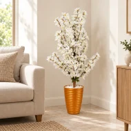 Arbre artificiel à fleurs blanches avec pot orange métallisé dans un coin de salon – Plantora