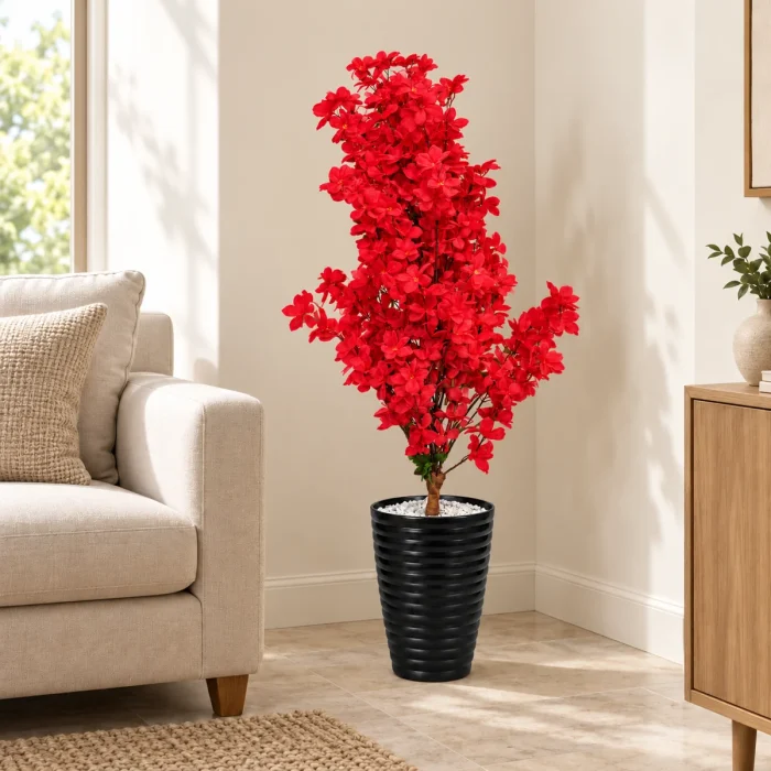 Arbre artificiel à fleurs rouges avec pot noir dans un coin de salon – Plantora
