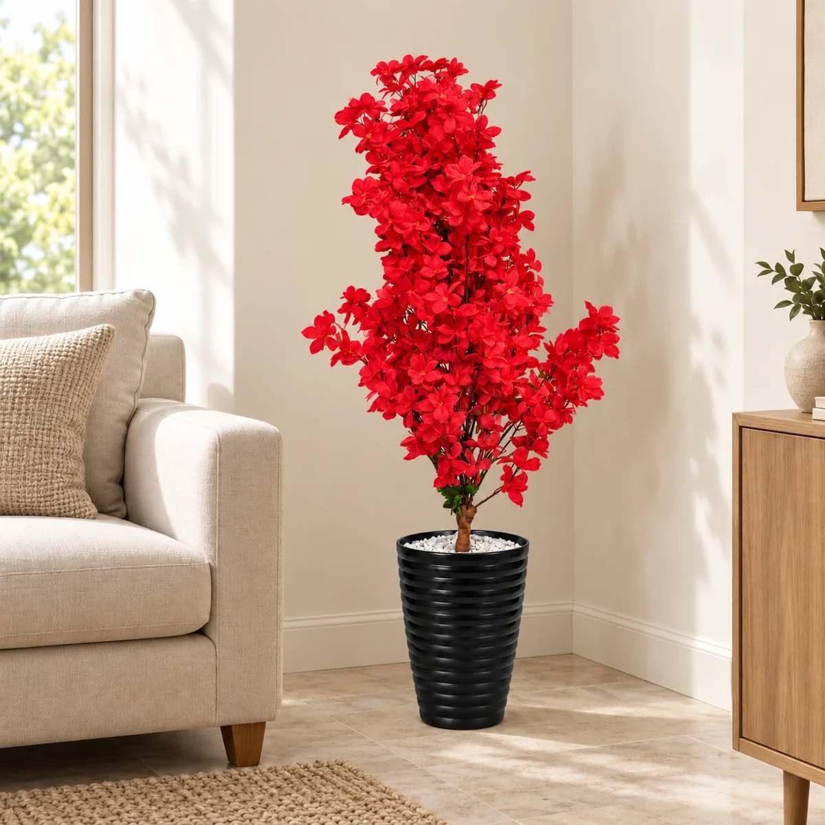 Arbre artificiel à fleurs rouges avec pot noir dans un coin de salon – Plantora